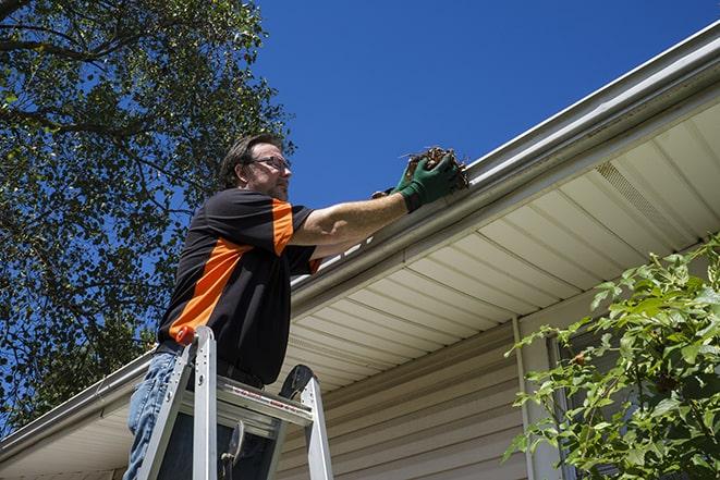 a repairman working on a broken gutter system in Bedford Heights